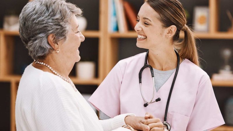 healthcare-insurance-senior-woman-patient-nurse-consulting-during-checkup-retirement-home-medical-support-wellness-with-medicine-professional-talking-mature-female-scaled (1)